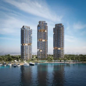Daytime waterfront view of the three residential towers at The Edit at d3 with marina and yachts in the foreground, located in Dubai Design District, Presented by Tohid Fetrat
