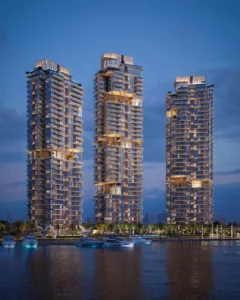 Nighttime waterfront view of the three illuminated residential towers at The Edit at d3 with yachts in the foreground, located in Dubai Design District, Presented by Tohid Fetrat