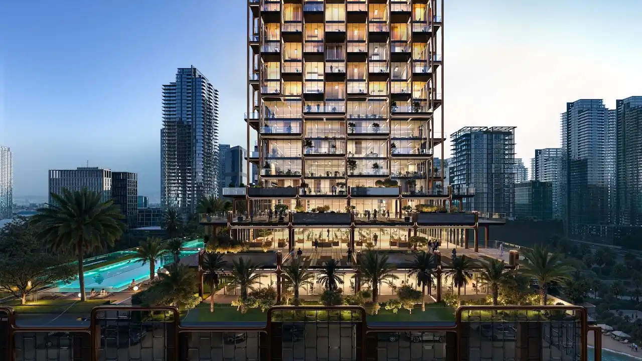 Evening view of The Symphony Tower by Imtiaz showcasing illuminated terraces, stacked balconies, landscaped podium levels, and surrounding Dubai skyline, Presented by Tohid Fetrat