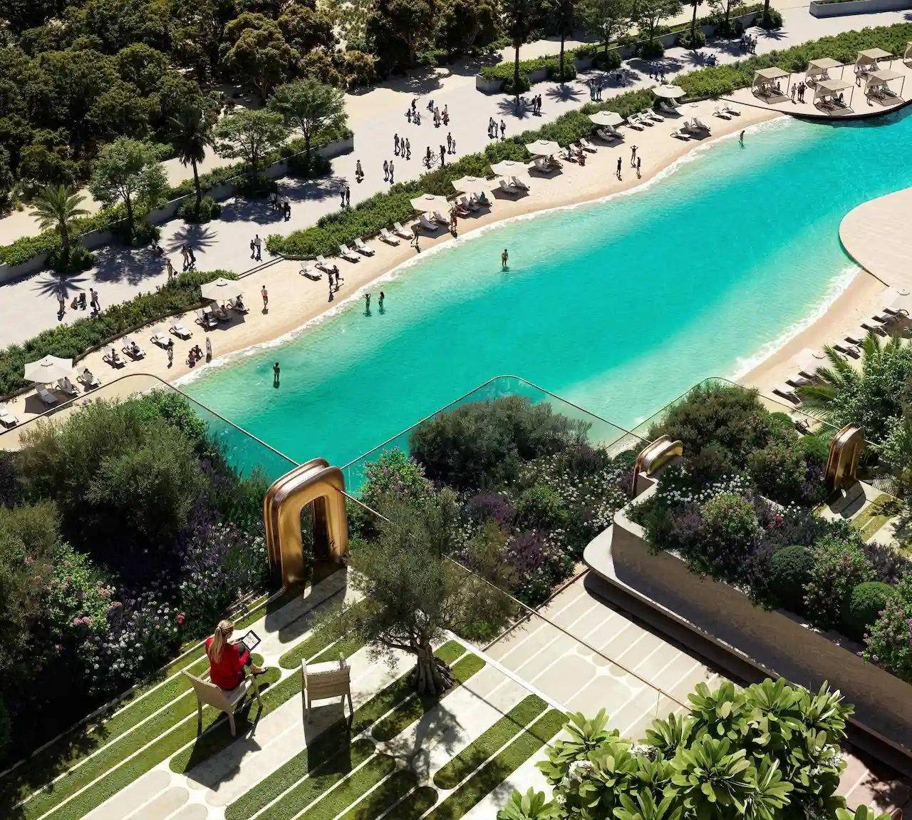 Aerial view of the lagoon-style pool at The Symphony Tower by Imtiaz, featuring turquoise waters, private cabanas, sun loungers, landscaped gardens, and a pedestrian promenade designed for resort-inspired living in Dubai, Presented by Tohid Fetrat