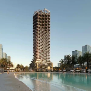 The Symphony Tower by Imtiaz overlooking a lagoon-style waterfront, featuring a modern high-rise design with illuminated balconies and palm-lined surroundings in Dubai, Presented by Tohid Fetrat