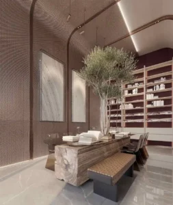Luxury library and reading area at The Symphony Tower by Imtiaz featuring a sculptural solid-wood table, indoor tree centerpiece, built-in bookshelves, refined mesh wall textures, and contemporary architectural lighting, Presented by Tohid Fetrat