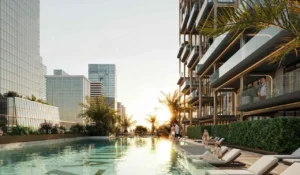 Luxury outdoor pool deck at The Symphony Tower by Imtiaz featuring resort-style swimming pool, sun loungers, landscaped greenery, and modern residential architecture in Dubai, Presented by Tohid Fetrat