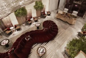 Luxury residential lobby seating area at The Symphony Tower by Imtiaz featuring sculptural velvet sofas, elegant side tables, indoor greenery, and a refined reception desk within a contemporary marble-finished interior, Presented by Tohid Fetrat