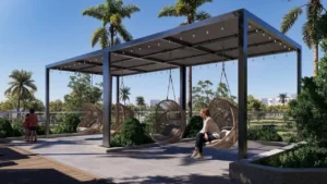 Outdoor lounge area at Inara Residence in Dubai featuring a modern pergola with hanging chairs, landscaped gardens, and palm-lined open spaces, presented by Tohid Fetrat