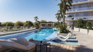 Outdoor swimming pool at Inara Residence in Dubai featuring sun loungers, private cabanas, landscaped greenery, and contemporary residential architecture, presented by Tohid Fetrat