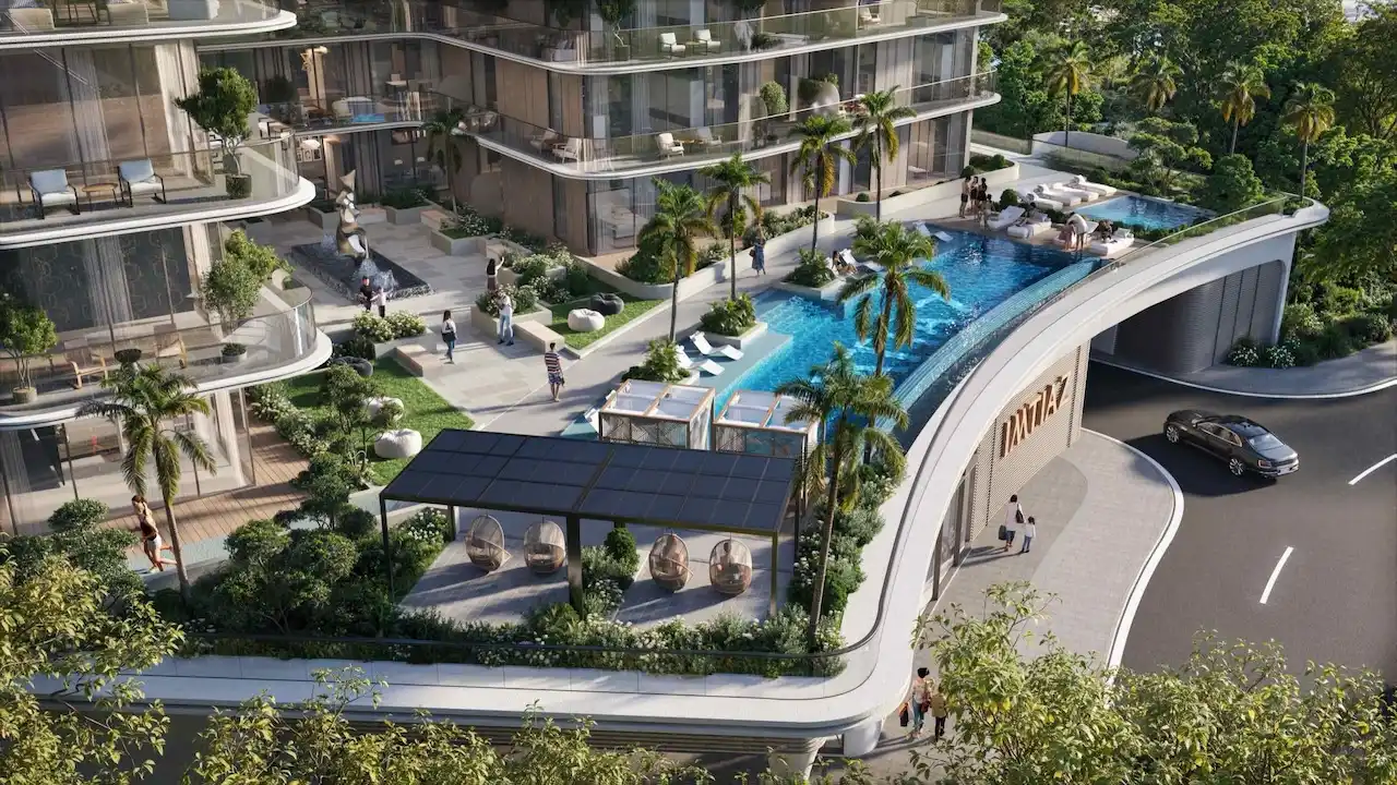 Podium-level exterior view of Inara Residence in Dubai, featuring a landscaped courtyard with swimming pool, palm trees, seating areas, modern balconies, and an elegant residential entrance, presented by Tohid Fetrat