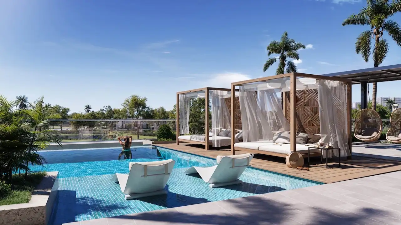 Rooftop swimming pool with private cabanas at Inara Residence in Dubai featuring sun loungers, shaded daybeds, landscaped greenery, and a resort-style relaxation environment, presented by Tohid Fetrat