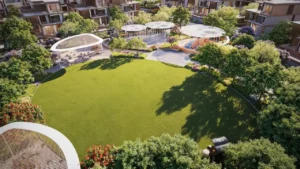 Central community park at Nad Al Sheba Gardens Phase 11 featuring open green lawn, shaded seating areas, water feature and children play zone Presented by Tohid Fetrat