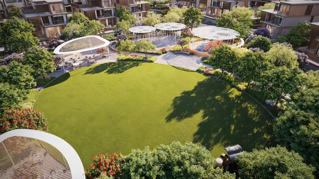 Central community park at Nad Al Sheba Gardens Phase 11 featuring open green lawn, shaded seating areas, water feature and children play zone Presented by Tohid Fetrat