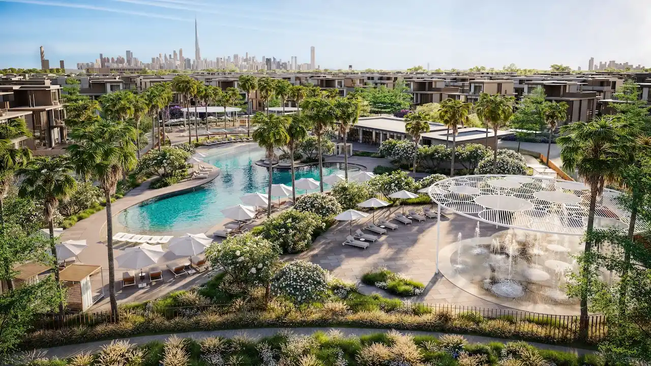 Resort style lagoon pool and outdoor amenities at Nad Al Sheba Gardens Phase 11 with palm trees, lounge areas and Dubai skyline in the background Presented by Tohid Fetrat