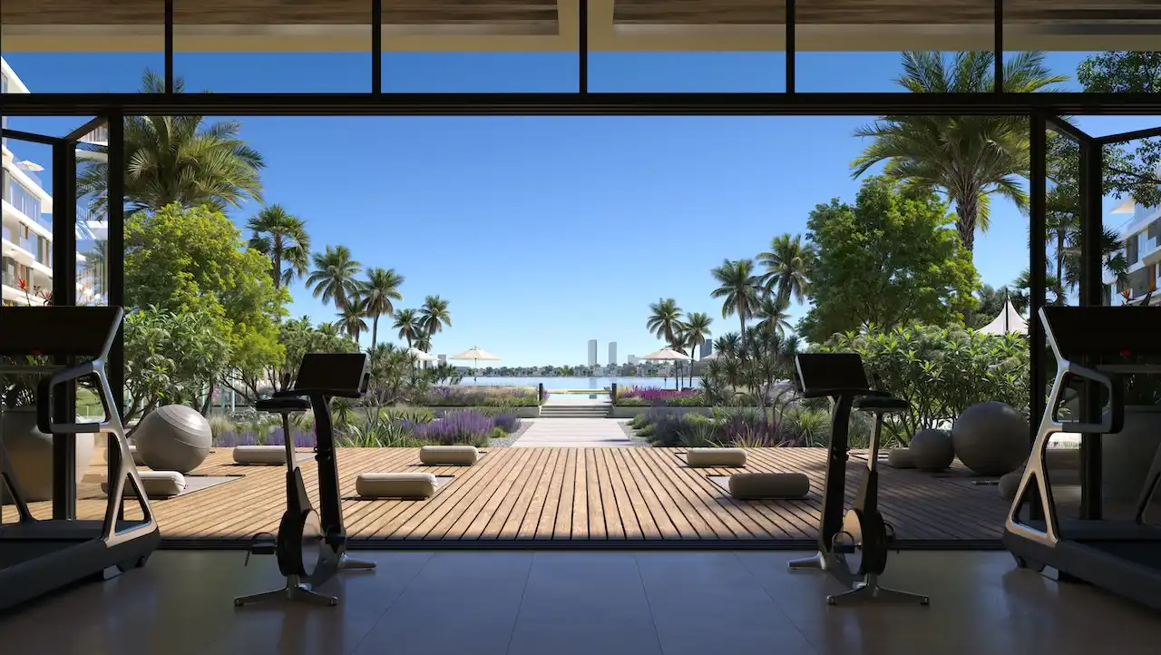 Palm Central Frond M Residences at Palm Jebel Ali fitness area opening to landscaped garden and waterfront view Dubai - Presented by Tohid Fetrat