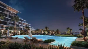 Palm Central Frond M Residences infinity pool night view overlooking waterfront lagoon at Palm Jebel Ali Dubai - Presented by Tohid Fetrat