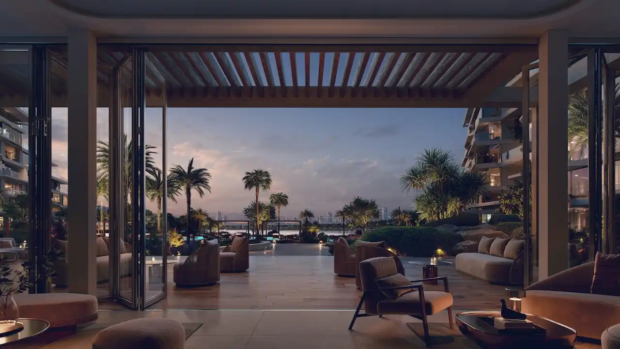 Palm Central Frond M Residences residents lounge opening to landscaped terrace and waterfront evening view at Palm Jebel Ali Dubai - Presented by Tohid Fetrat