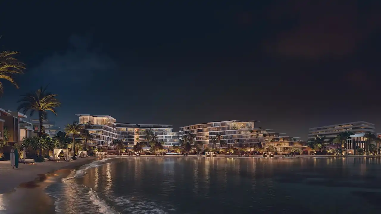 Palm Central Frond M Residences at Palm Jebel Ali waterfront buildings illuminated at night overlooking lagoon Dubai - Presented by Tohid Fetrat