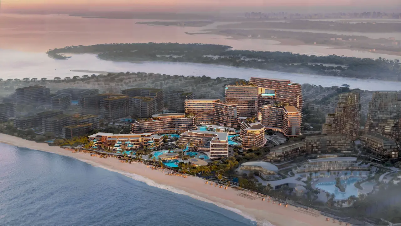 Coastal aerial view of The Meriva Collection by Ellington at sunrise featuring beachfront residences, lagoon pools and panoramic waterfront setting in Dubai Presented by Tohid Fetrat