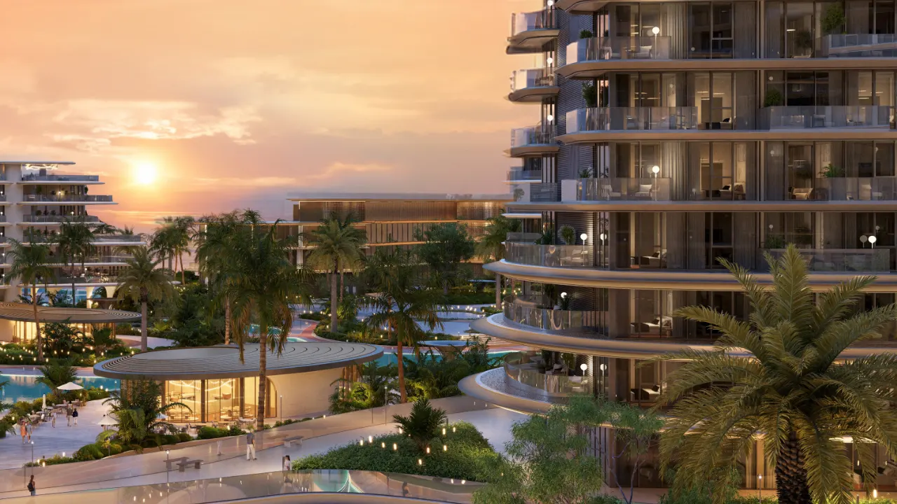 Exterior view of The Meriva Collection by Ellington at sunset showing curved balconies, landscaped gardens and resort style pool areas in Dubai Presented by Tohid Fetrat