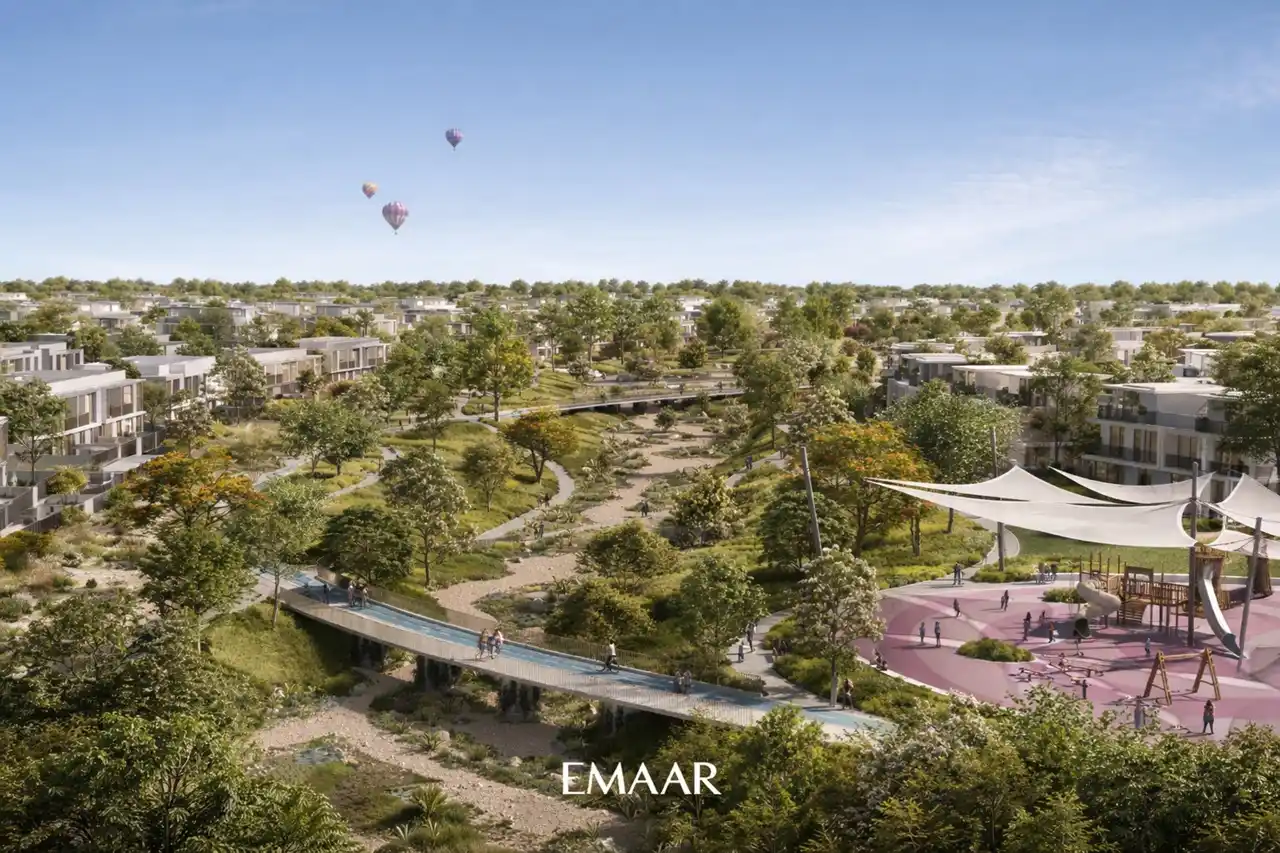 Aerial view of The Valley by Emaar master community featuring landscaped parks pedestrian bridges and a shaded family playground in Dubai Presented by Tohid Fetrat