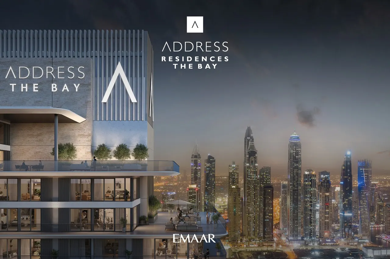 Address Residences The Bay at Emaar Beachfront by Emaar exterior tower view with illuminated Dubai skyline at night Presented by Tohid Fetrat