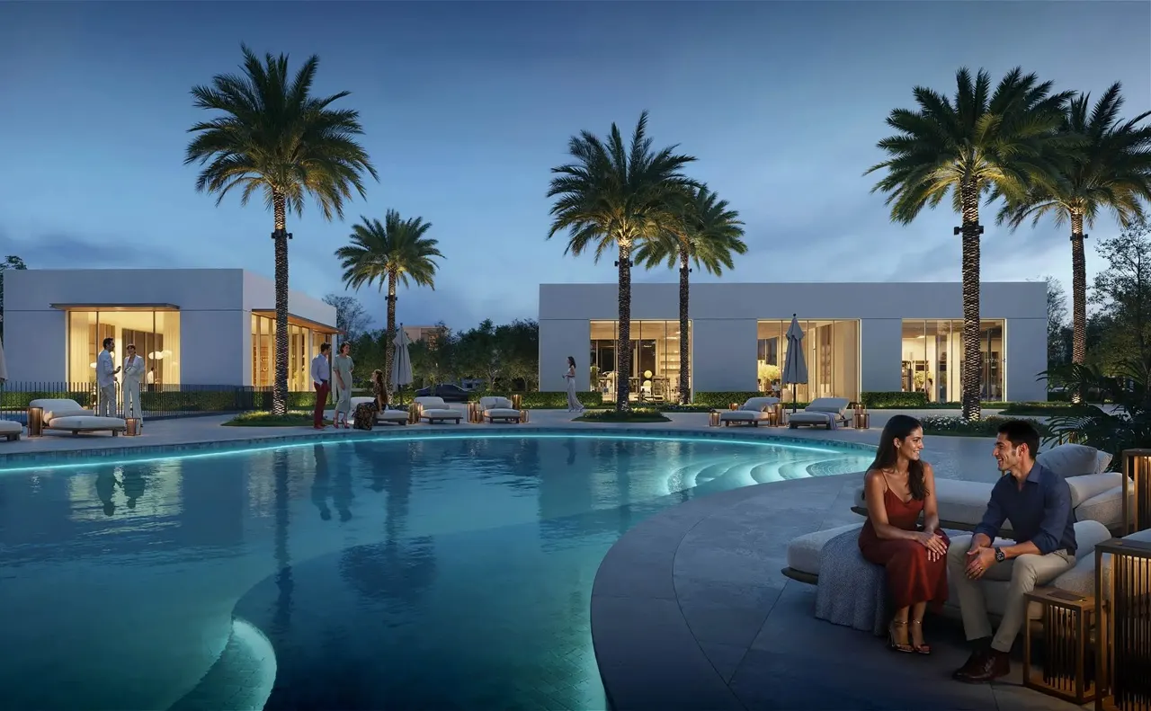 Avelia at The Valley by Emaar luxury villa community poolside evening scene with palm trees and outdoor seating in Dubai - Presented by Tohid Fetrat