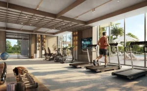 Ovelle at The Valley by Emaar fitness gym interior with treadmills strength equipment and garden views through large windows in Dubai - Presented by Tohid Fetrat