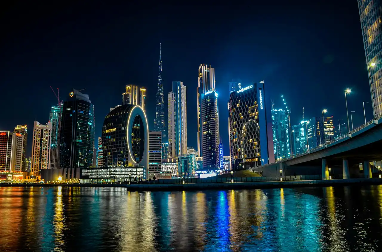 Dubai skyline at night featuring Burj Khalifa and Business Bay waterfront representing property insurance coverage not covered scenarios in Dubai Presented by Tohid Fetrat