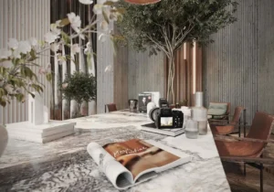 marble table with decor books camera and seating in luxury lobby at Sunset Bay Grand by Imtiaz Dubai Islands Presented by Tohid Fetrat