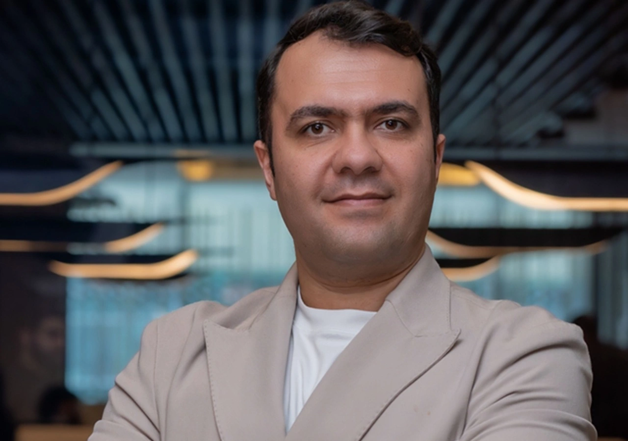 Professional portrait of a Dubai real estate advisor in a modern luxury interior setting with elegant lighting and contemporary design