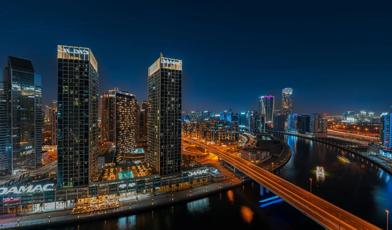 Where to apply for Dubai Golden Visa represented by Business Bay Dubai skyline waterfront towers and urban infrastructure at night Presented by Tohid Fetrat