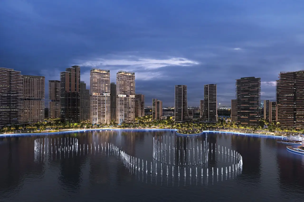 Artistry Two Residences by Select Group waterfront community night view with illuminated towers and fountain display in Dubai - Presented by Tohid Fetrat