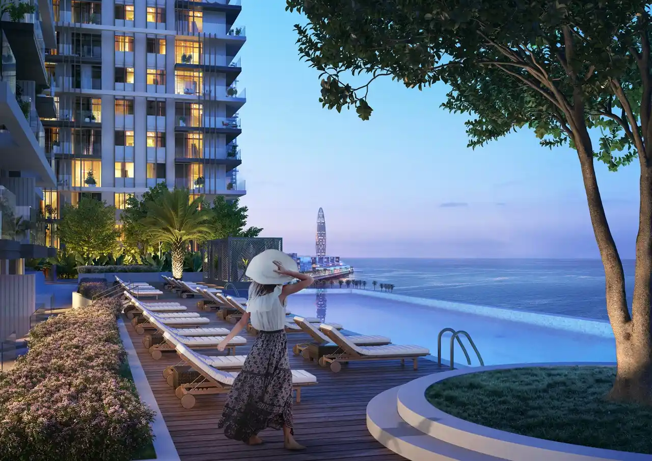 Beach Isle at Emaar Beachfront by Emaar infinity pool deck at sunset overlooking the Gulf with landscaped surroundings in Dubai - Presented by Tohid Fetrat
