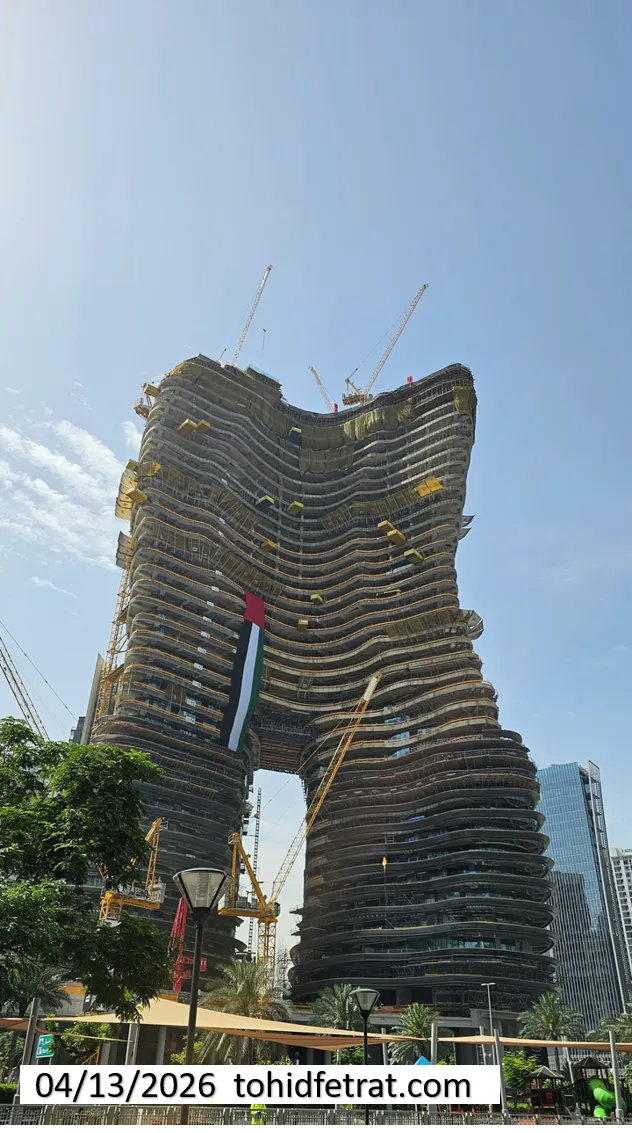 Bugatti by Binghatti construction update in April 2026 showing curved twin tower structure with cranes and facade progress in Dubai - Captured by Tohid Fetrat