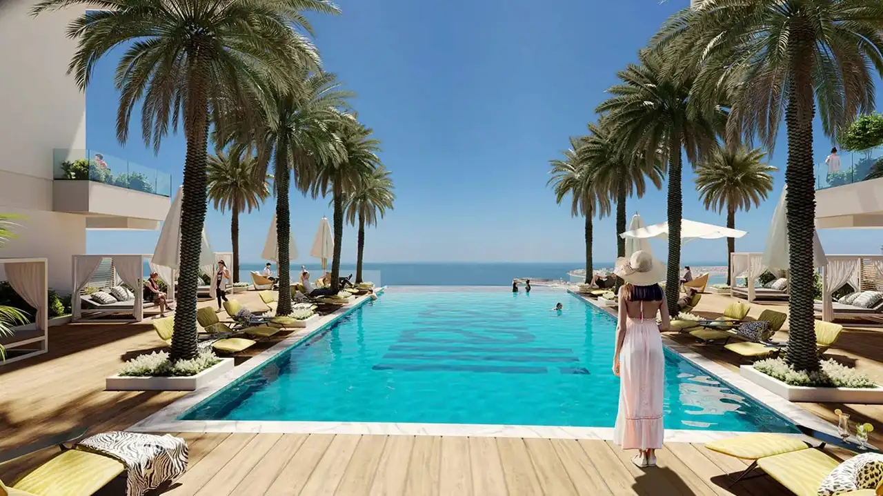 Cavalli Tower by DAMAC infinity pool with palm lined deck luxury loungers and sea view in Dubai - Presented by Tohid Fetrat