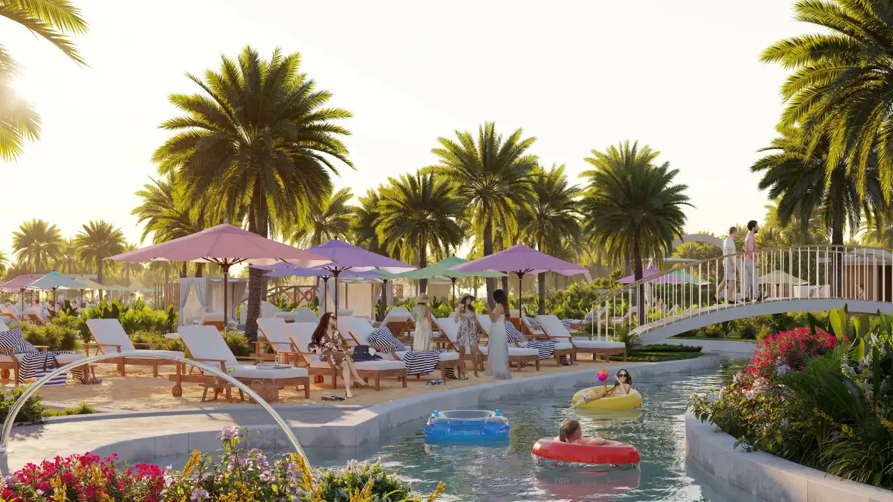 DAMAC Hills 2 by DAMAC Properties lagoon with floating rings sun loungers umbrellas palm trees and pedestrian bridge in Dubai - Presented by Tohid Fetrat