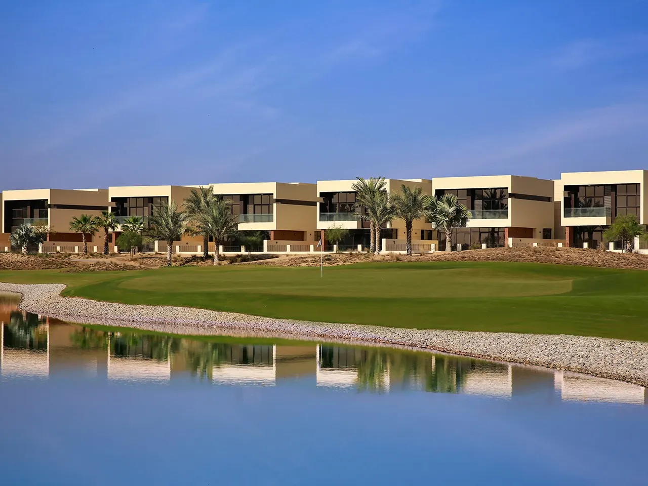 DAMAC Hills villas overlooking golf course with landscaped greens palm trees and water feature in Dubai Presented by Tohid Fetrat