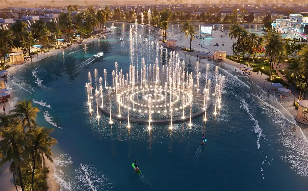 DAMAC Islands by DAMAC Properties illuminated lagoon fountain with waterfront villas and palm lined promenade at sunset in Dubai - Presented by Tohid Fetrat