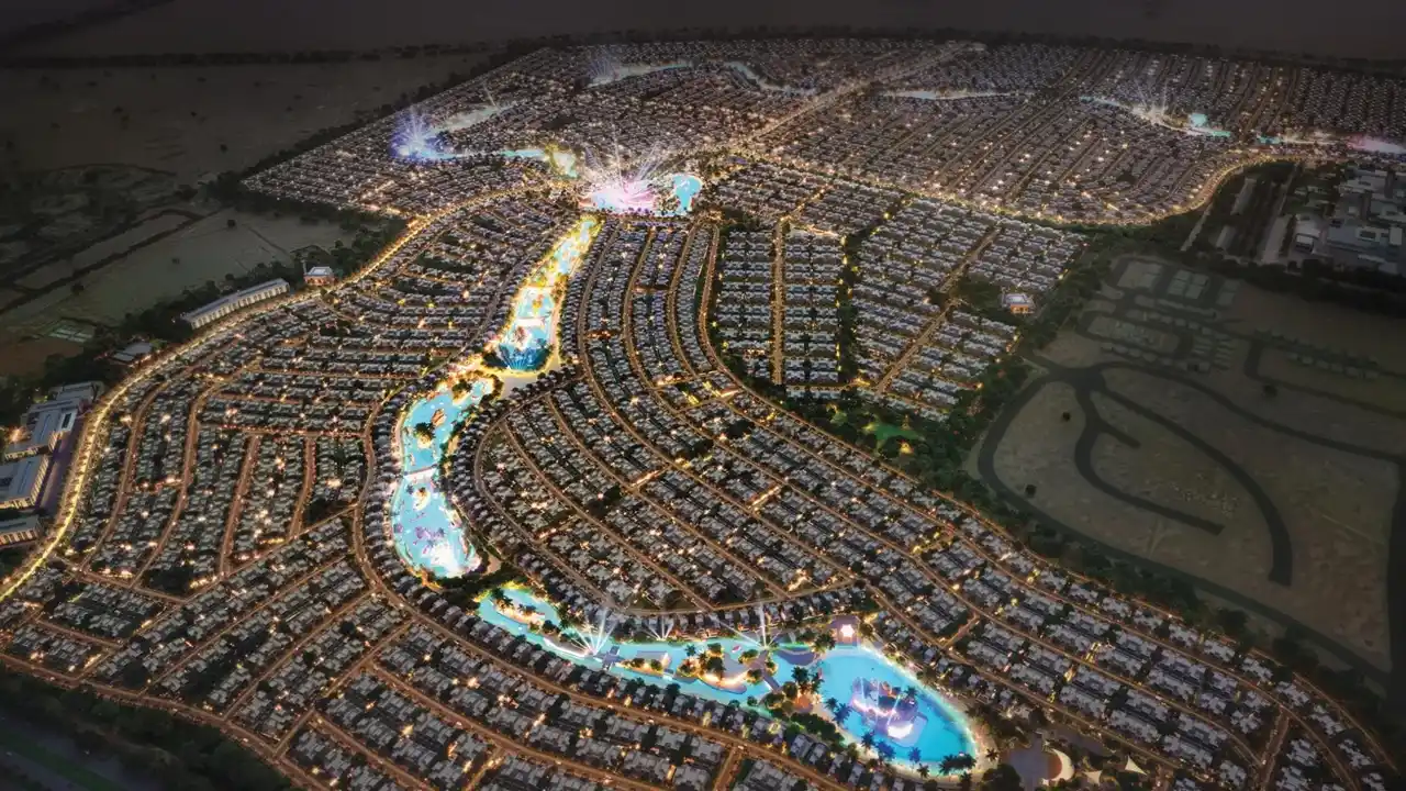 DAMAC Lagoons master plan aerial view showing community layout waterfront lagoons residential clusters and illuminated streets at night in Dubai Presented by Tohid Fetrat