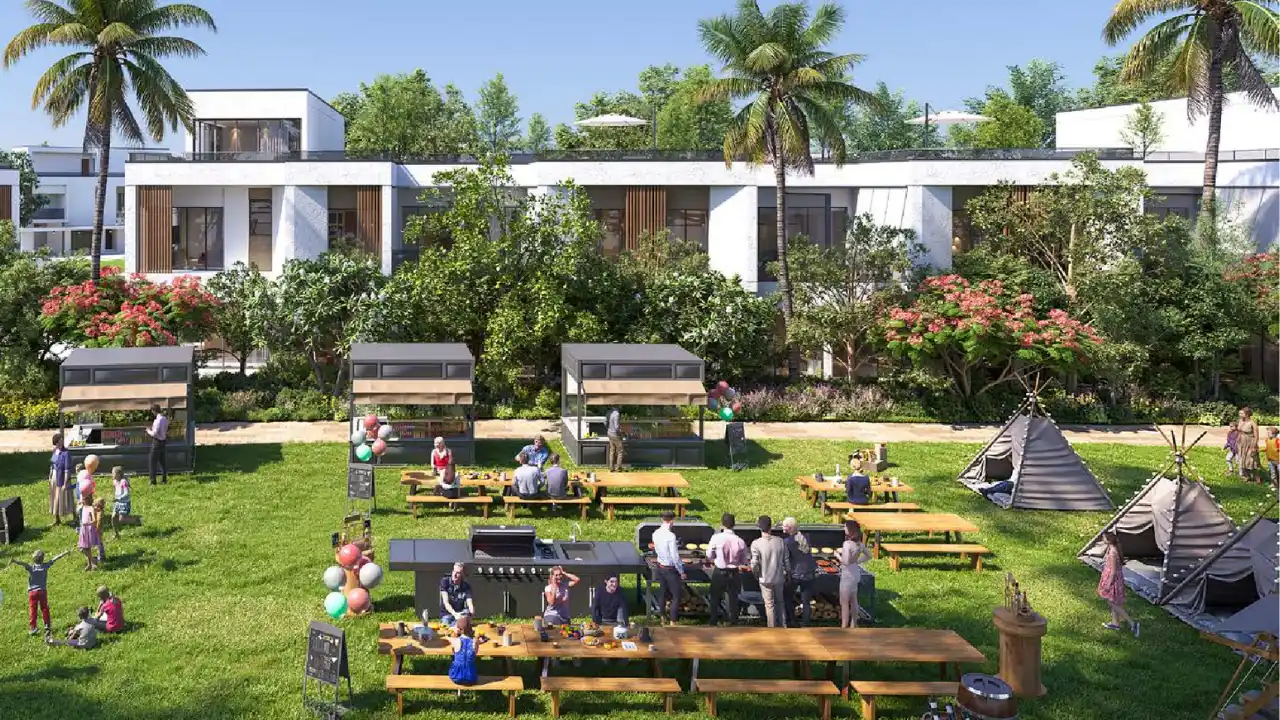DAMAC Riverside by DAMAC Properties community garden social space with outdoor dining tables barbecue area and landscaped greenery in Dubai - Presented by Tohid Fetrat