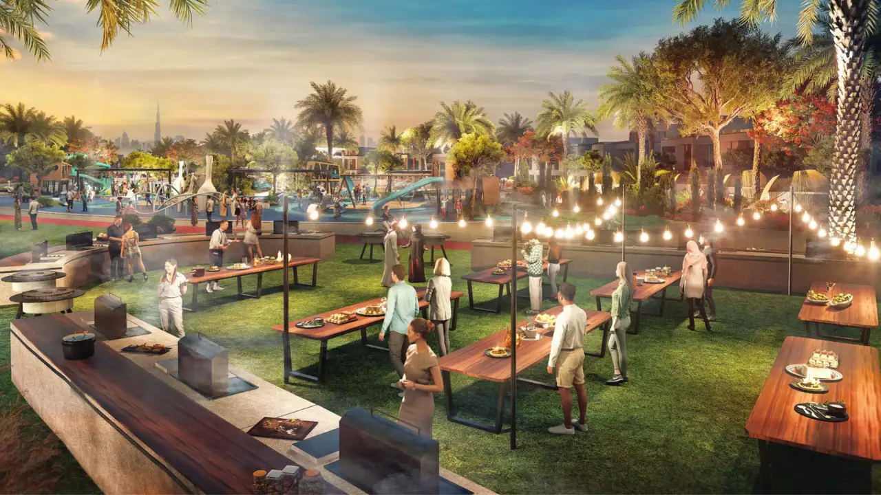 DAMAC Riverside by DAMAC Properties evening community barbecue area with outdoor dining tables festoon lighting and landscaped park setting in Dubai - Presented by Tohid Fetrat