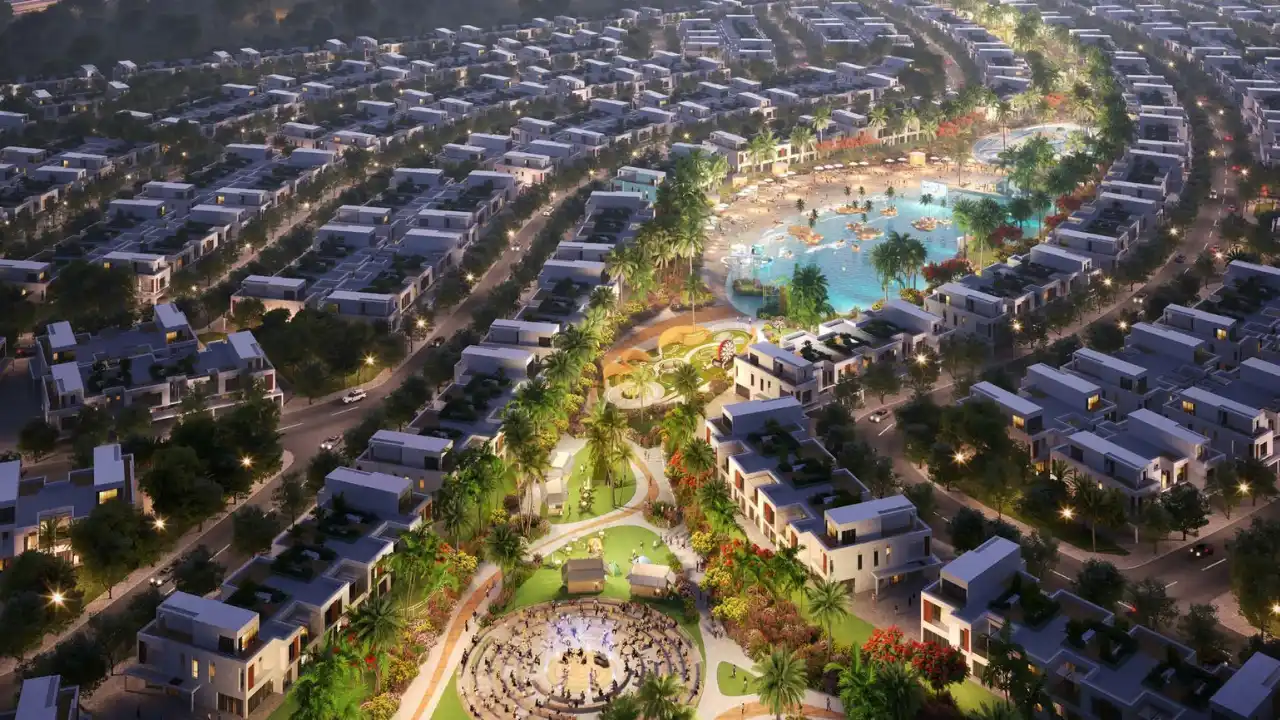 DAMAC Riverside by DAMAC Properties aerial masterplan with central lagoon landscaped parks and residential villas illuminated at night in Dubai - Presented by Tohid Fetrat
