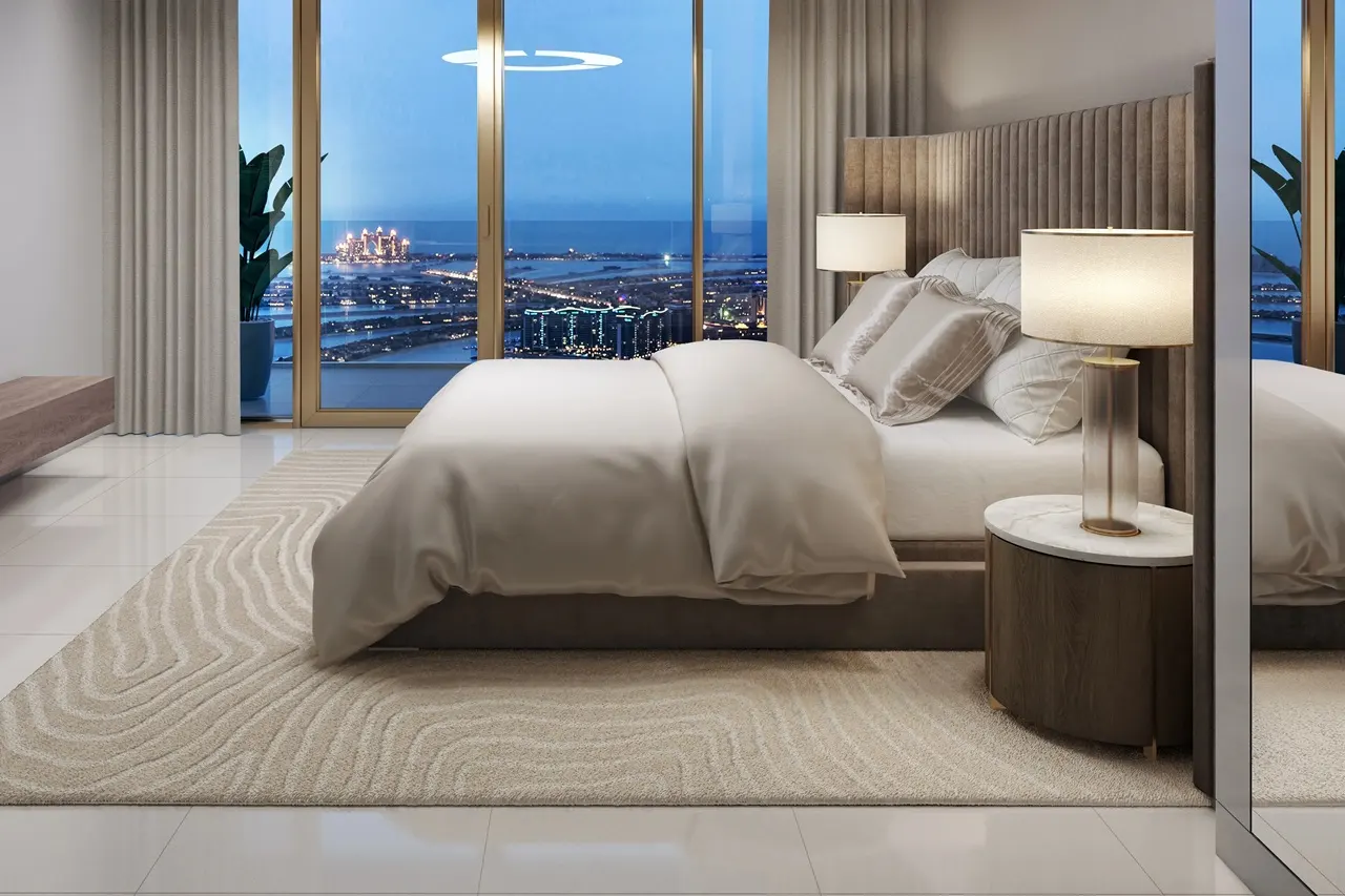 Grand Bleu Tower at Emaar Beachfront by Emaar luxury bedroom with upholstered headboard soft lighting and panoramic Palm view through floor to ceiling windows in Dubai - Presented by Tohid Fetrat