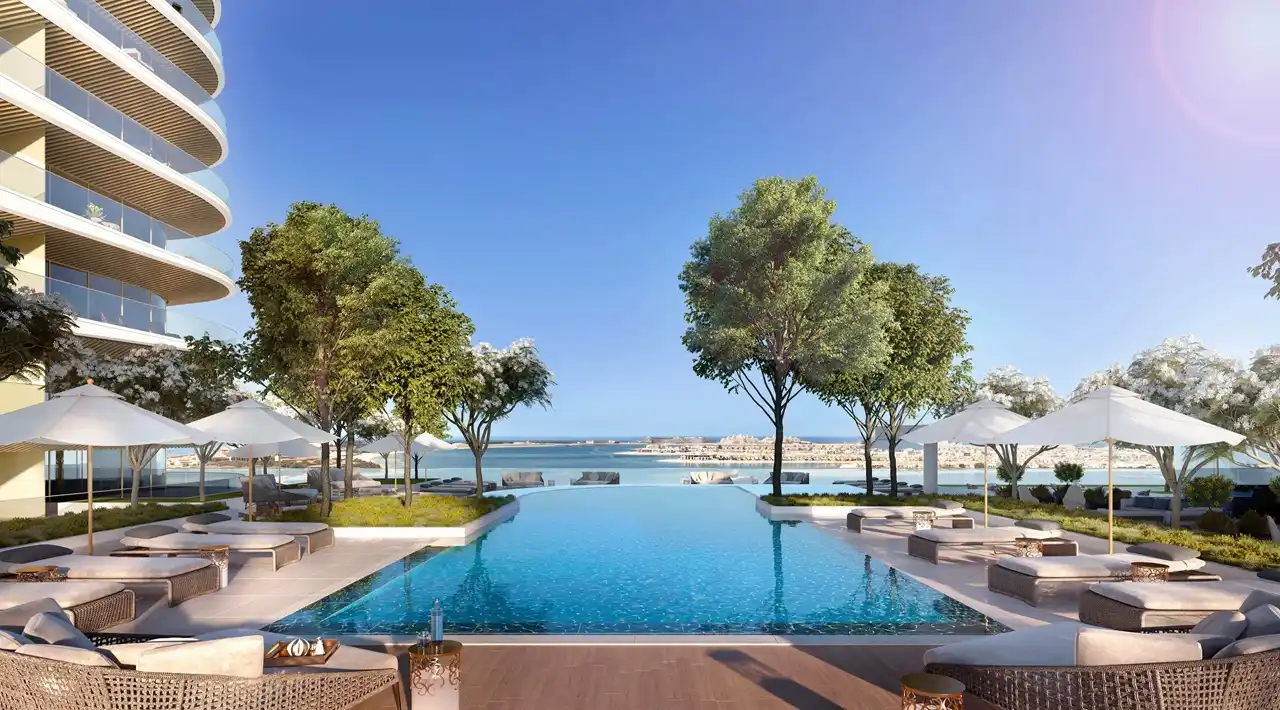 Grand Bleu Tower at Emaar Beachfront by Emaar infinity pool with sun loungers shaded seating and sea view in Dubai - Presented by Tohid Fetrat