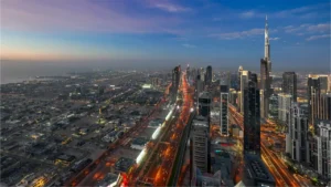 North-facing view from LUMENA by Omniyat showing Burj Khalifa skyline, Sheikh Zayed Road, and Jumeirah Beach coastline at dusk - Presented by Tohid Fetrat
