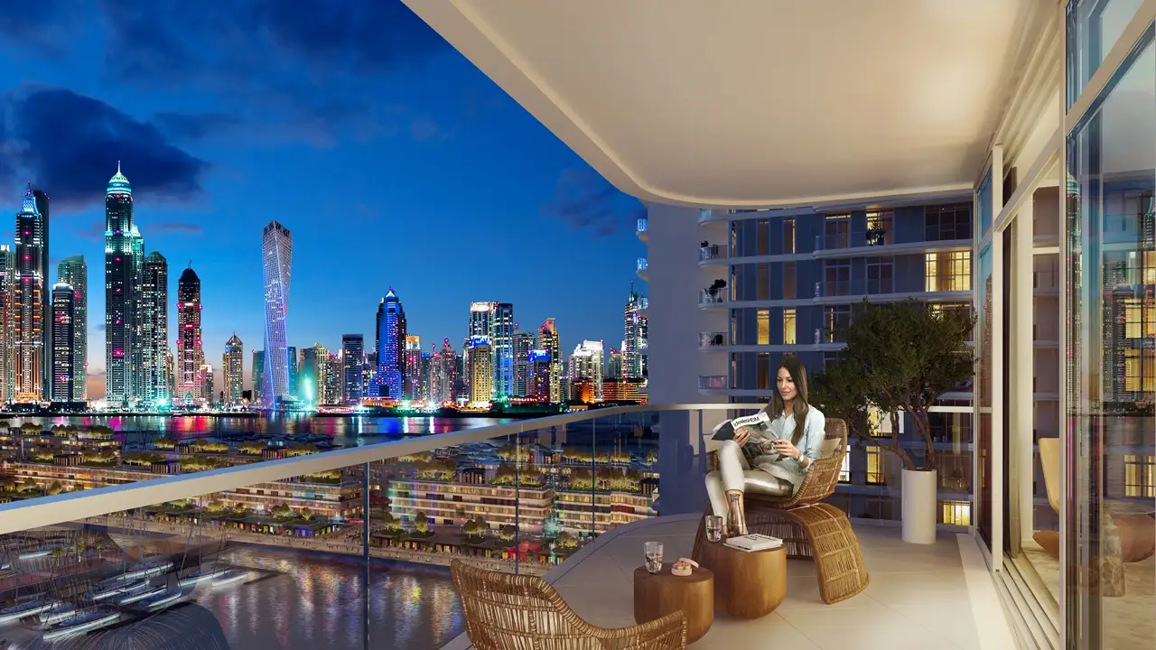 Marina Vista at Emaar Beachfront by Emaar balcony with seating overlooking Dubai Marina skyline at night in Dubai - Presented by Tohid Fetrat