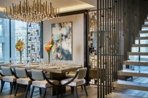 One at Palm Jumeirah Dorchester Collection by Omniyat dining area with statement chandelier and staircase detail in Dubai - Presented by Tohid Fetrat