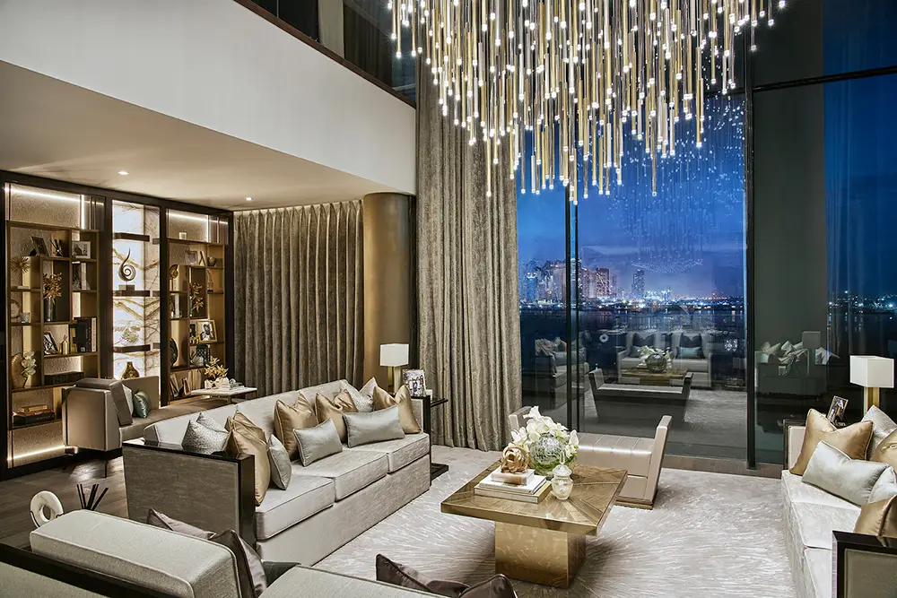 One at Palm Jumeirah Dorchester Collection by Omniyat double height living room with chandelier and night skyline view in Dubai - Presented by Tohid Fetrat