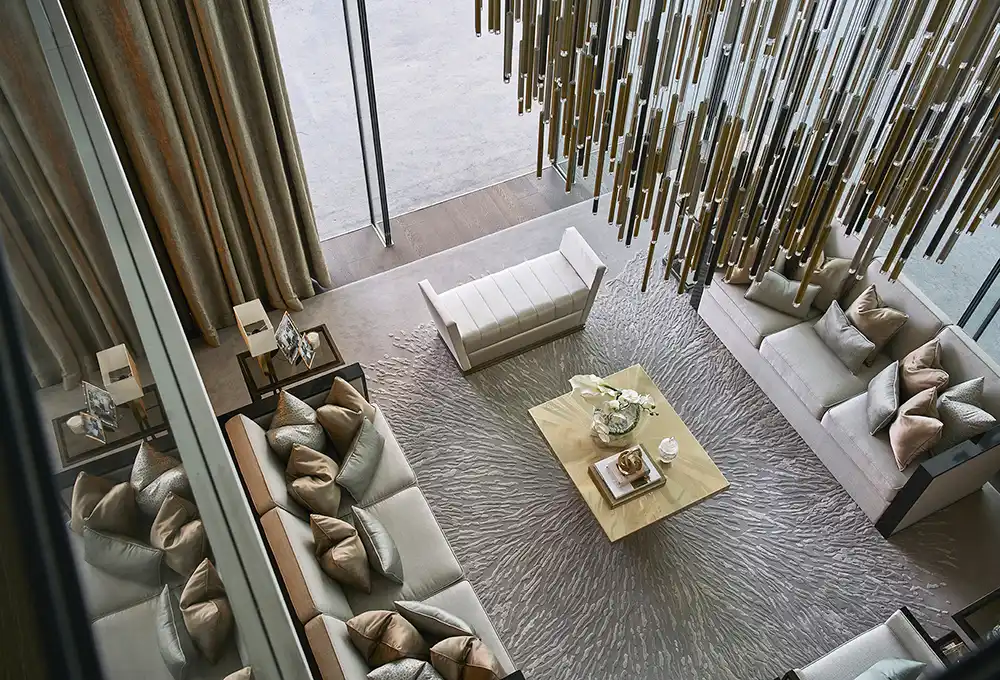 One at Palm Jumeirah Dorchester Collection by Omniyat double height living room with chandelier and lounge seating in Dubai - Presented by Tohid Fetrat