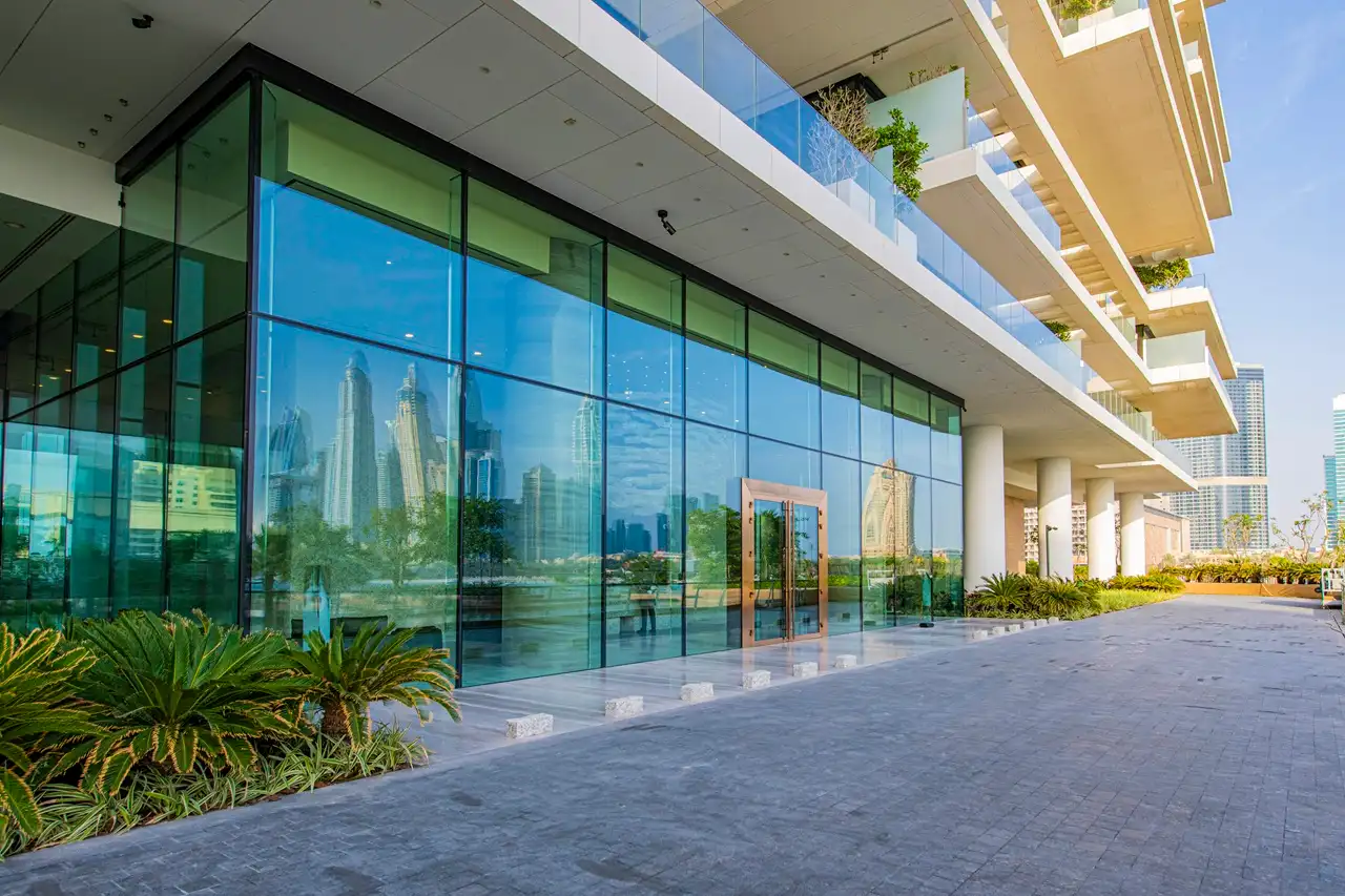 One at Palm Jumeirah Dorchester Collection by Omniyat glass facade entrance with skyline reflections in Dubai - Presented by Tohid Fetrat