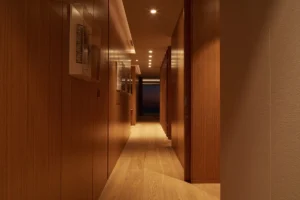 One at Palm Jumeirah Dorchester Collection by Omniyat hallway with wood paneling warm lighting and minimalist design in Dubai - Presented by Tohid Fetrat