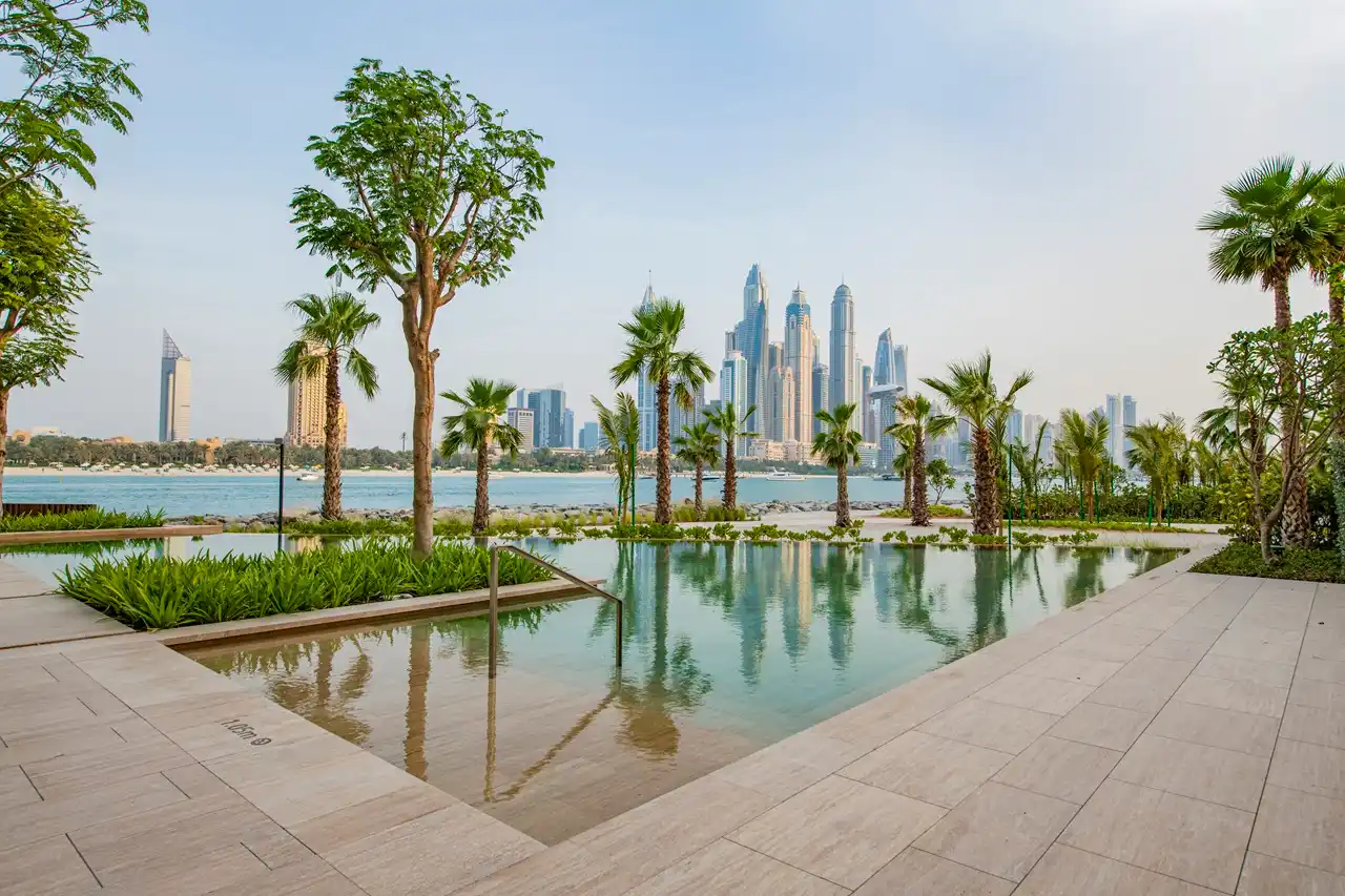 One at Palm Jumeirah Dorchester Collection by Omniyat infinity pool with palm trees and skyline views in Dubai - Presented by Tohid Fetrat